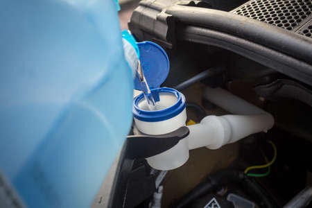 adding winter windscreen washer fluid in the carの写真素材