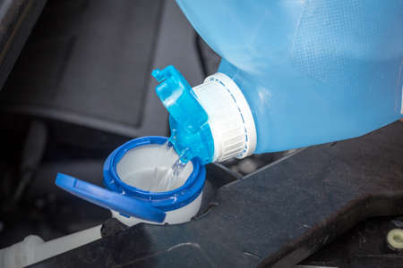 adding windscreen washer fluid in the carの写真素材