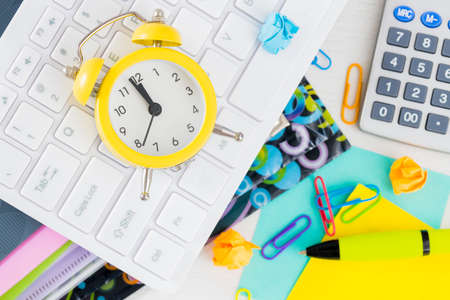 calculator and alarm clock for five to twelve. Clutter on the desk, office accessories. Concept, Accounting, Deadlineの写真素材