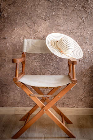 Director chair with a striped on the basis, an elegant womens hat, Vintage style. empty placeの写真素材