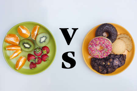 Healthy and unhealthy, Fruit plate vs biscuit plate, Concept, Good food choice, Bright background