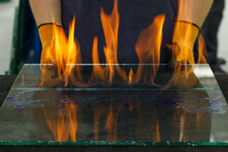 Burning glass, Laminated VSG material, Cut in a workshop. A specialist burns through the foil breaking the glued glassの写真素材