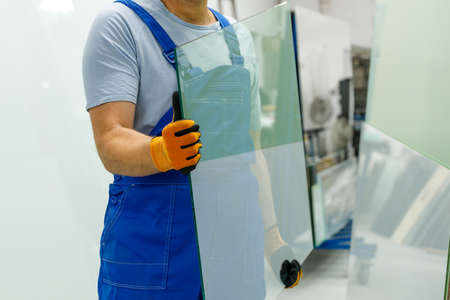 The glazier carries the glass in the glass factoryの写真素材