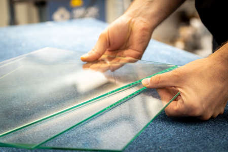 a glazier holding transparent panes in his handsの写真素材