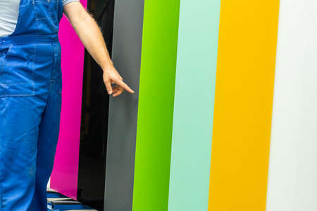 a worker in a glass factory shows different types of colored glass