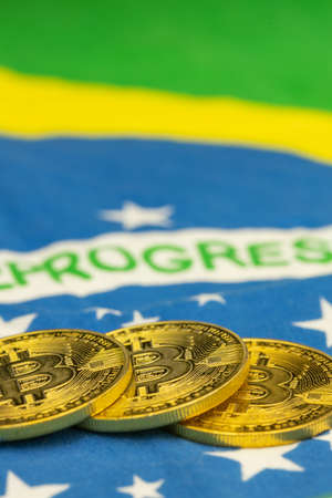 Bitcoin cryptocurrency lying against the background of the flag of Brazil, Business and financial...