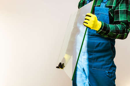 Glazier holding in his hands a piece of thick glass pane, a lot of space for text