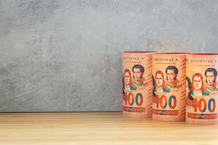 Bolivian currency, Rolls of money, 100 Boliviano banknotes lined up next to each other, Empty space for textの写真素材
