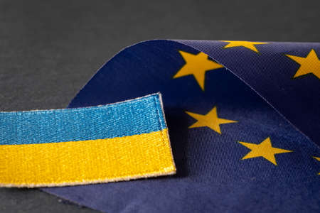 The concept of Ukraine joining the European Union, the Ukrainian flag lying next to the Symbol of EU starsの写真素材