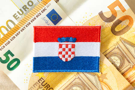 The flag of Croatia against the background of the single currency of the European Union, The concept...