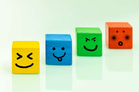 Colorful wooden blocks with emoticons Positive emotions, smiles, facial expressions, Concept of...