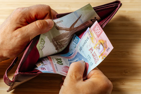 Hand takes money out of wallet, Mexico Peso banknotes, Concept, rising prices, value of Mexican...