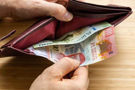 Hand takes money out of wallet, Mexico Peso banknotes, Concept, rising prices, value of Mexican...