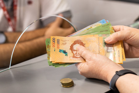Costa Rica money, A woman stands at the cash register with a lot of cash in her hand, Concept, Cash...
