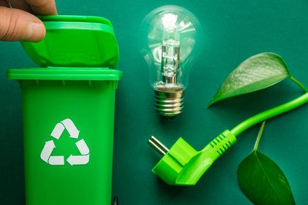 Recycling bin, Green cable and glowing light bulb, Environmental concept, Creative approach, Modern management of natural resources, Energy generation, Care for the environmentの写真素材