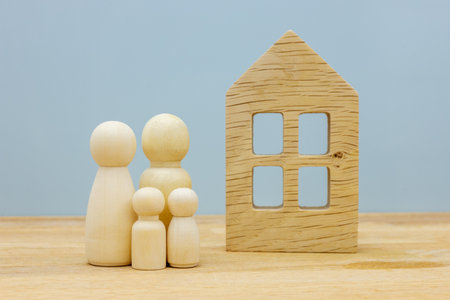 Dream house Concept, Wooden figures, Happy family with children standing in front of their own home, Housing conceptの写真素材