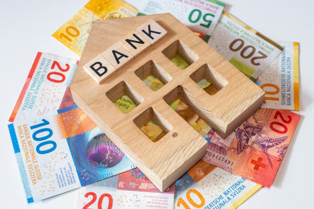 Miniature bank of switzerland and a bundle of swiss francs, business concept, banking business, financial stabilization, lending, foreign exchange market, close upの写真素材