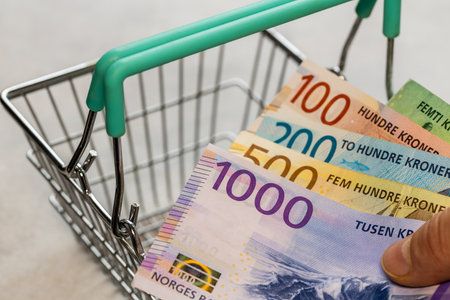 Norwegian money with an empty shopping cart, Concept, rising prices in stores, Increasingly expensive shopping, Inflation in Norway, business and financeの写真素材
