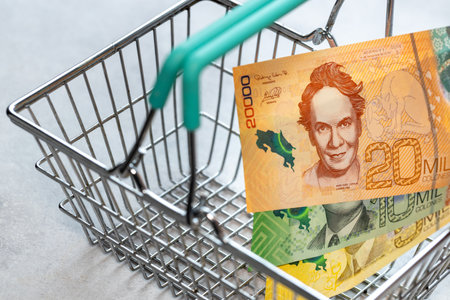 Concept, inflation in Costa Rica, Empty shopping cart and Costa Rican money colones, close upの写真素材