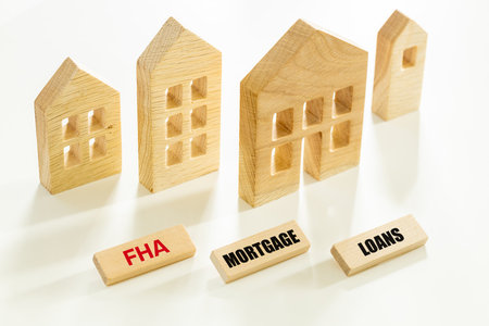 Eligibility for FHA loans, Social program supporting the purchase of a house despite financial problems and for people with reduced creditworthiness, words on wooden FHA, Mortgage, loans, miniature housesの写真素材