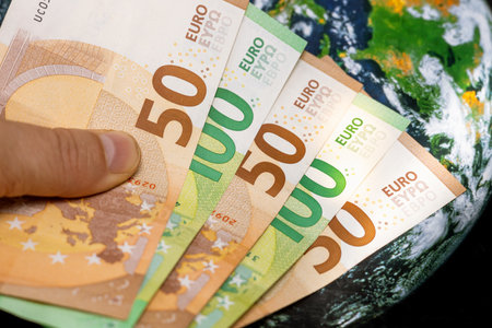 euro currency against the background of the world, concept, financial analysis of the euro zone, exchange rates, financial policy of the European Union, revenues from exports and importsの写真素材