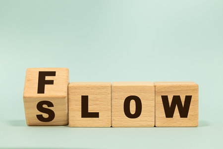 Flow and Slow symbol. Concept words Flow and Slow on wooden cubes. Business and Flow and Slow concept. Beautiful blue background. Copy space.の写真素材