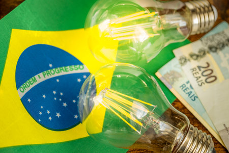 Cost of electricity in Brazil, economic and financial concept. Brazilian flag, two burning light bulbs and moneyの写真素材