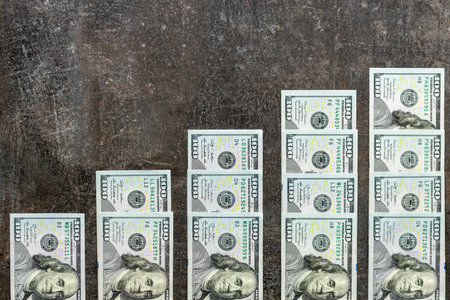 American dollar. 100 dollar bills stacked upwards. Increasing scale. Financial concept, market analysis, copy spaceの写真素材