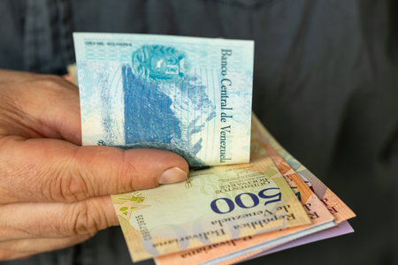 venezuela money, man counts banknotes. Cash in hand, financial business concept, state of household budgets of Venezuelansの写真素材