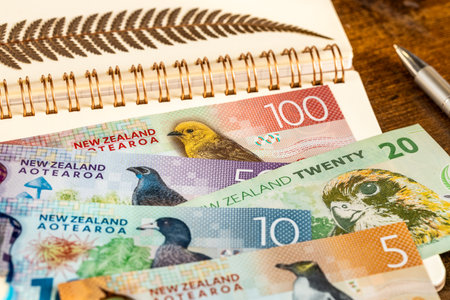 New Zealand dollars and a dried silver fern leaf lying on a beautiful notebook. Financial concept, Symbols of New Zealandの写真素材