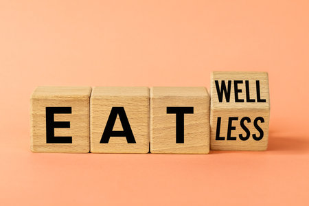 Motivational symbol Eat Less vs Eat Well. Conceptual words. Rotated wooden block with words Eat Less vs Eat Well. Medical psychology. Healthy diet. Beautiful apricot background. Copy spaceの写真素材