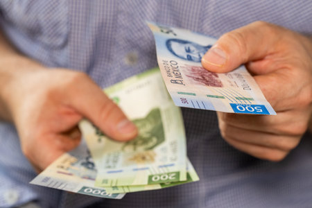 Mexico money. Man giving someone a 500 peso bill, Business conceptの写真素材