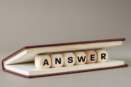 ANSWER concept. Word answer on wooden blocks placed in a book. education concept, knowledge search, answer to questions. copy spaceの写真素材