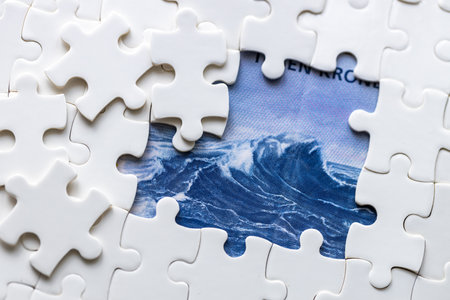 Norwegian krone hidden under puzzle pieces, business concept, Norwegian currency, market analysis, NOK exchange rate. copy space, close upの写真素材