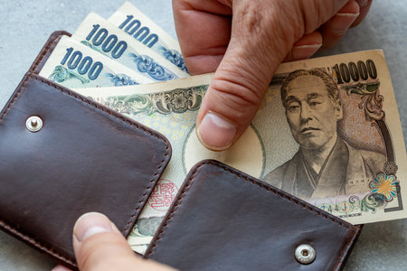 Japan money. Hand reaching into wallet for Japanese yen. Financial concept, Home budget, billing and paymentsの写真素材