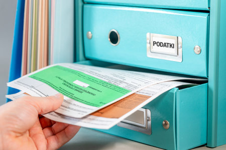 Taxes Poland. Personal income tax settlement. Financial concept. Person reaching into a drawer for forms to settle the annual personal income tax in Polandの写真素材