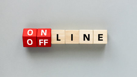 Online and Offline. Concept of accessibility in business. Red wooden cubes change the word Online to Offline. Gray background, Flat lay, copy spaceの写真素材