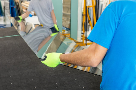 Glaziers place a large sheet of thick glass on the table by hand. Glass workの写真素材