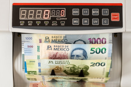 Mexico money. electric machine counts Mexican peso banknotes. Business and financial concept