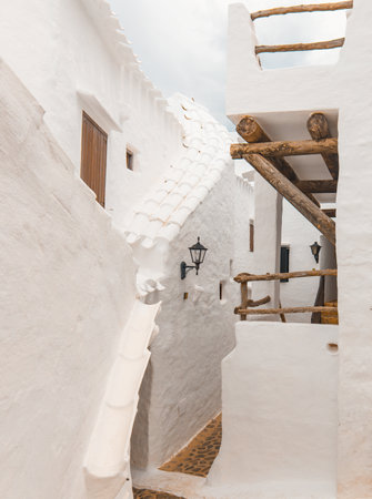 The charming town of Binibeca on Menorca. Narrow streets and white walls of houses with wooden elements, Mediterranean architecture, wonderful Spain.の写真素材