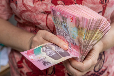Indonesia money. Financial success concept. Woman holding big bundle of Indonesian rupiah. One hundred thousand banknotes,の写真素材