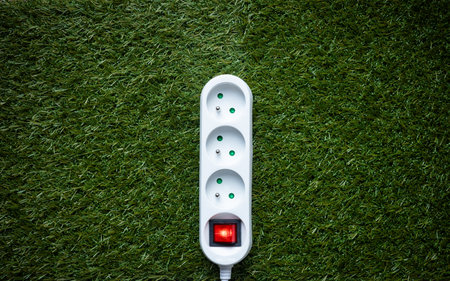 Power strip on the grass. Environmental concept. Green energy, modern technologies and renewable energy sourcesの写真素材