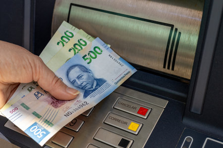 Mexico money. A woman withdraws money from an ATM. Financial concept. Mexican pesoの写真素材
