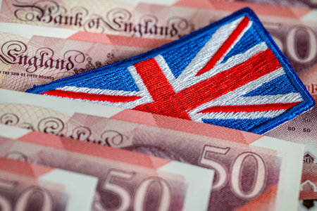 The flag of Great Britain sticking out from between money. Business concept. Financial center. Market analysis, British pound exchange rate, United Kingdom economy. close upの写真素材