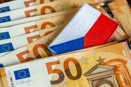 A Czech flag sticking out from between Euro banknotes. A financial concept. Meeting the conditions and preparing the Czechs for joining the Eurozoneの写真素材