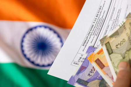 Indian taxes. A man holds an Indian income tax form and a rupee file in front of the Indian flag. The concept of financial settlement in Indiaの写真素材