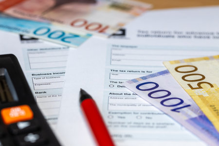 Norwegian taxes. Tax return with pen and calculator. Tax calculation. Krone banknotes. Norway financial settlement concept. close upの写真素材