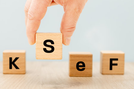 Hand arranging wooden blocks into the symbol KSeF. National e-invoice system. Financial, business, and fiscal concepts. A system used for issuing invoices online. close upの写真素材