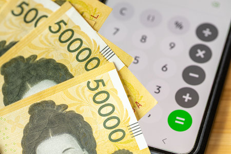 South Korean money. A calculator on your phone and 50,000 won banknotes. Financial concept, expense analysis, household budget, and financial calculations. close upの写真素材