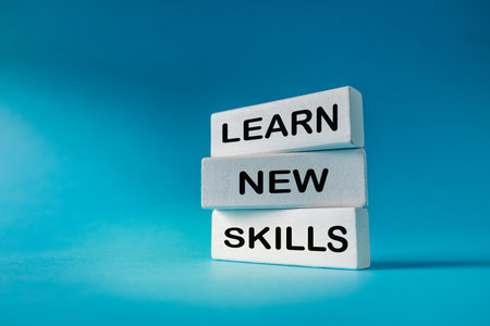 Learn new skills. Business concept. Slogan Learn New Skills written on white elements on a beautiful blue background. Development and education. Expanding horizons and building a career. copy spaceの写真素材